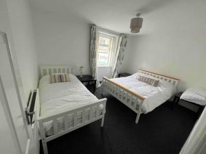 a bedroom with two beds and a window at Fisherman Cottage Morecambe in Morecambe