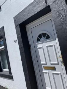 a white door on the side of a building at Fisherman Cottage Morecambe in Morecambe