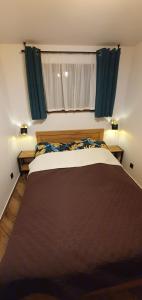 a bedroom with a large bed with green curtains at Domki letniskowe "U Adaska" in Chałupy