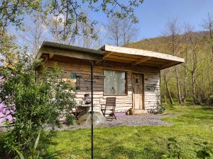 a small log cabin with a table and a chair at The Cabins Conwy in Conwy