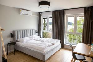 a bedroom with a bed and two windows at Przystań Posmakuj in Tereszewo