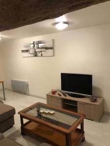 a living room with a tv and a coffee table at Maison chaleureuse au centre ville in Nérac