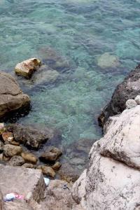 a body of water with rocks and the clear water at Exclusive Location with direct access to the Sea in Deia