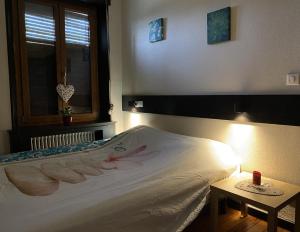 1 dormitorio con 1 cama, ventana y mesa en L’aile droite du château, en Lebétain