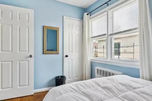 a bedroom with blue walls and a bed and a window at Rockaway 3 bedroom suite by the Sea. in Wave Crest