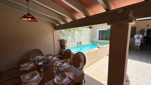 a dining room with a table and a swimming pool at Casa Padrina Burballa in Maria de la Salut