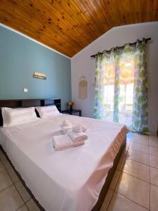 a bedroom with a large white bed with towels on it at Mia's Home in Kalamata