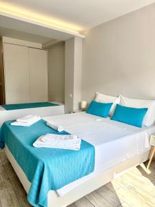 1 dormitorio con 1 cama blanca grande con almohadas azules en Enjoy Viana - Guest House, en Viana do Castelo