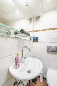 Baño blanco con lavabo y aseo en Gemütliche 3-ZKB WC SouterrainWohnung in Bestlage en Hamburgo