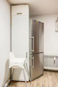 a white chair sitting in front of a refrigerator at Gemütliche 3-ZKB WC SouterrainWohnung in Bestlage in Hamburg