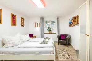 1 dormitorio con 2 camas y 1 silla en Gemütliche 3-ZKB WC SouterrainWohnung in Bestlage en Hamburgo