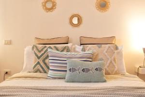 Un dormitorio con una cama con almohadas. en SARDINIA RE - Casa Luisa With Pool, en Alghero