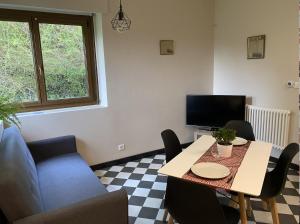 ein Wohnzimmer mit einem Tisch und einem Sofa in der Unterkunft L’aile droite du château in Lebétain