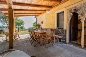 uma mesa de madeira e cadeiras num pátio em SARDINIA RE - Casa Luisa With Pool em Alghero