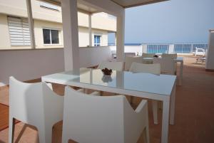 uma sala de jantar com uma mesa branca e cadeiras em Apartamentos Alborada em Cala Millor