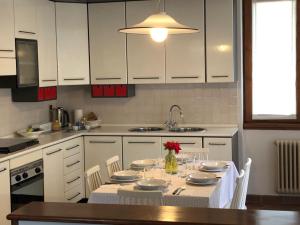 a kitchen with a table with plates and flowers on it at Acero Rosso in Malonno