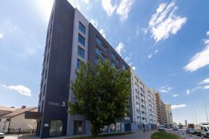 a tall black building with a tree in front of it at Apartament Luxury Two-bedroom in Białystok