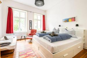 um quarto com 2 camas e uma cadeira vermelha em Großzügige Altbauwohnung in Bestlage em Hamburgo