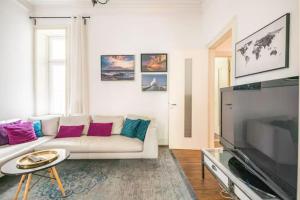 a living room with a white couch and a flat screen tv at Großzügige Altbauwohnung in Bestlage in Hamburg