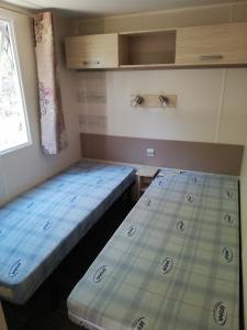 two beds in a small room with a window at mobil home Gassin in Gassin