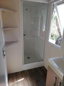 a shower with a glass door in a bathroom at mobil home Gassin in Gassin
