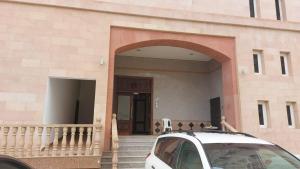 una macchina bianca parcheggiata di fronte a un edificio di شقة كبيرة مؤثثة بالكامل a Salalah