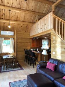 uma sala de estar com um sofá e uma mesa em Beddington Lake Log Cabin 