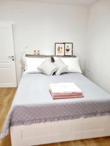 a bedroom with a white bed with two books on it at Vila Damir in Gradac