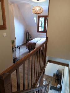 a room with a staircase with a bed and a window at Le manège Gite Le phare in Sainte-Marie-au-Bosc