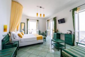 1 dormitorio con 1 cama, mesa y sillas en Borgo Romantica - Resort & Spa en Ischia