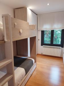 a bedroom with a bunk bed and two windows at CAL JAN - CADÍ in Bellver de Cerdanya 