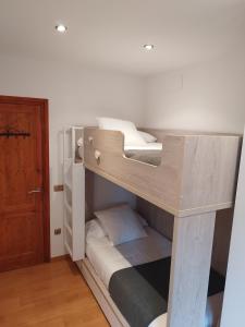 a bunk bed in a room with a door at CAL JAN - CADÍ in Bellver de Cerdanya 