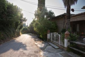 a dirt road next to a house with a fence at Guesthouse Elena , Vatos, Corfu in Vátos