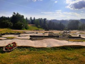 a field with a park with a large wooden structure at Ferienwohnung Wanderkönige in Braunlage