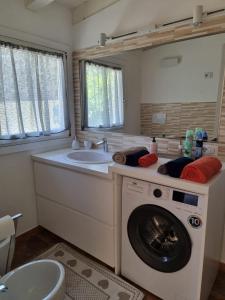 een badkamer met een wasmachine en een wastafel bij Lulamax Sardegna Olbia in Olbia