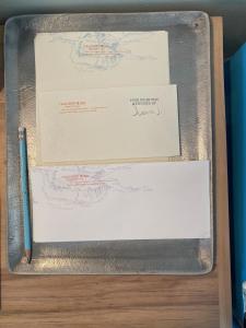 una scatola con due fogli di carta e una penna di Thunderbird Hotel a Marfa