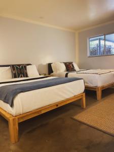 a room with two beds in a room with a window at Thunderbird Hotel in Marfa