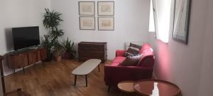 uma sala de estar com um sofá vermelho e uma televisão em Palazzo Moncada appartamento 2 em Palermo