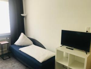 ein Wohnzimmer mit einem blauen Sofa und einem TV in der Unterkunft Hafencity Bremerhaven in Bremerhaven