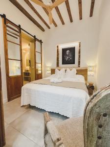 ein Schlafzimmer mit einem großen weißen Bett und einem Stuhl in der Unterkunft Julio Cesar in Cádiz