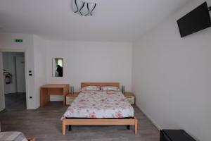 a bedroom with a bed and a tv on a wall at B&B DIVINO in Calceranica al Lago