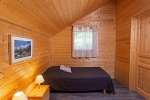 a bedroom with a bed in a wooden room at Chalet individuel à proximité de la station Les 7 Laux in Les Adrets +24 photos