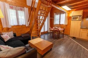 a living room with a couch and a table in a cabin at Chalet individuel à proximité de la station Les 7 Laux in Les Adrets