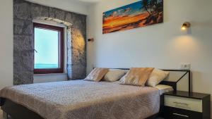 a bedroom with a bed and a window at Apartment Bugenvilija in Lovran