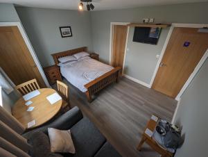 ein Wohnzimmer mit einem Bett und einem Tisch in der Unterkunft Wassells House Accommodation in Cheddar