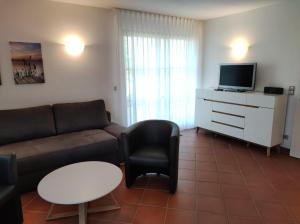 un soggiorno con un divano e una TV di Ferienwohnung Seeterrassen a Dewichow