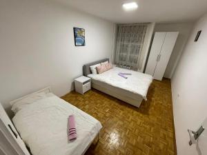 2 camas en una habitación pequeña con sábanas blancas en Apartman-Apartment-Stan Ilidža, en Sarajevo