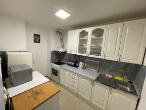 cocina con armarios blancos y nevera en Apartman-Apartment-Stan Ilidža, en Sarajevo