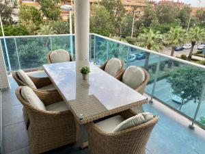 d'une table et de chaises sur un balcon avec vue. dans l'établissement VoraMar 3 Playa Puerto de Sagunto, à Sagonte