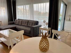 a living room with a couch and a pineapple on a table at VoraMar 3 Playa Puerto de Sagunto in Sagunto